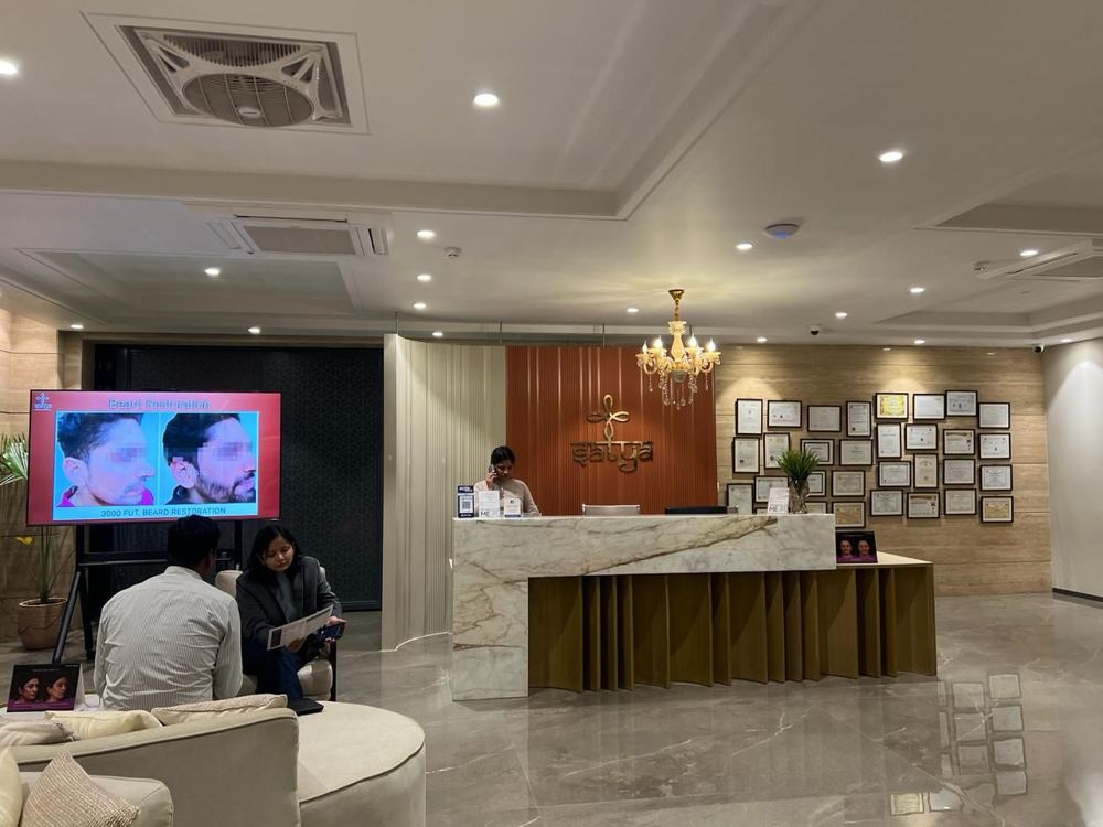 Reception with a marble-clad desk, chandelier and framed credentials wall