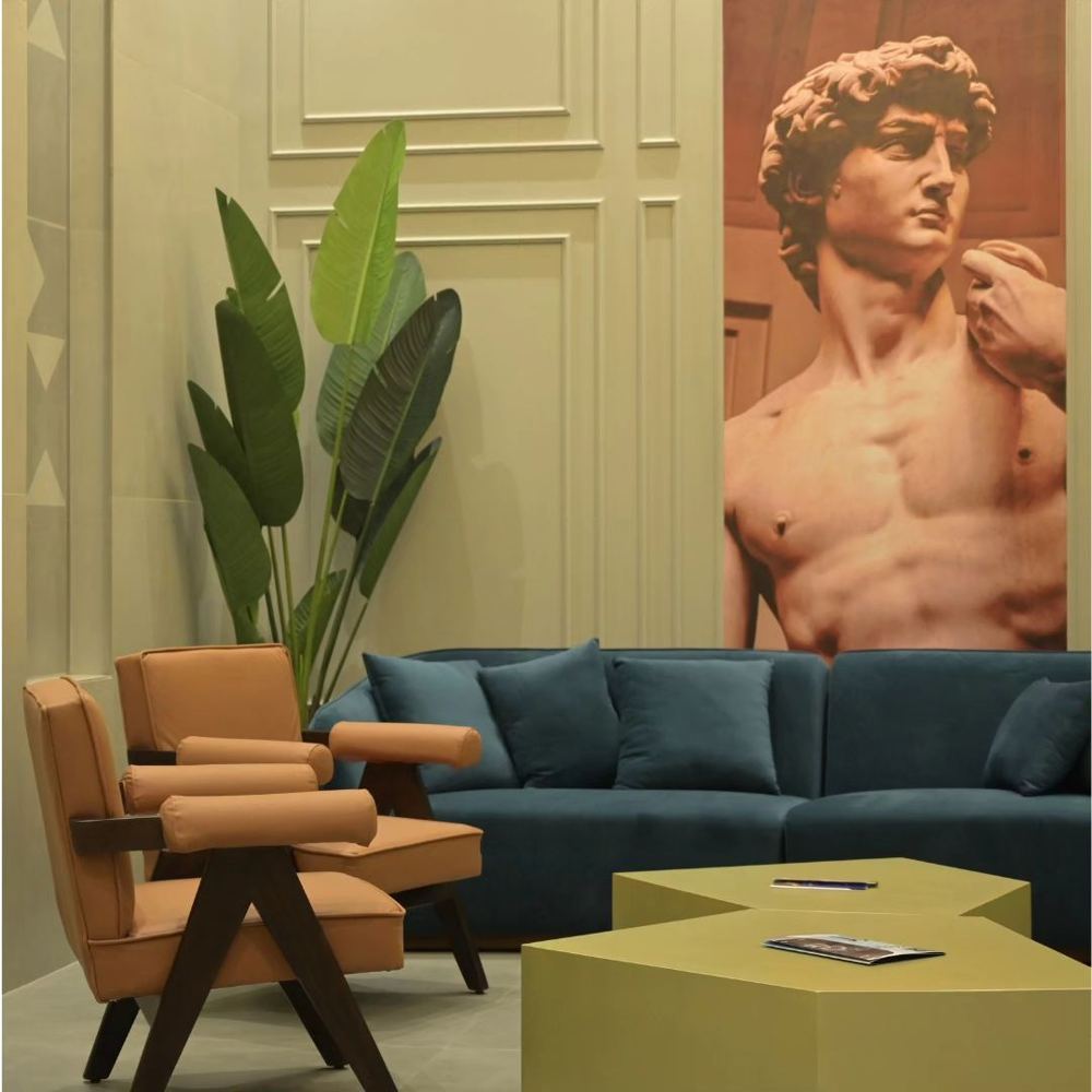 Lounge with olive panelled walls, a teal sofa, tan armchairs and a Renaissance mural